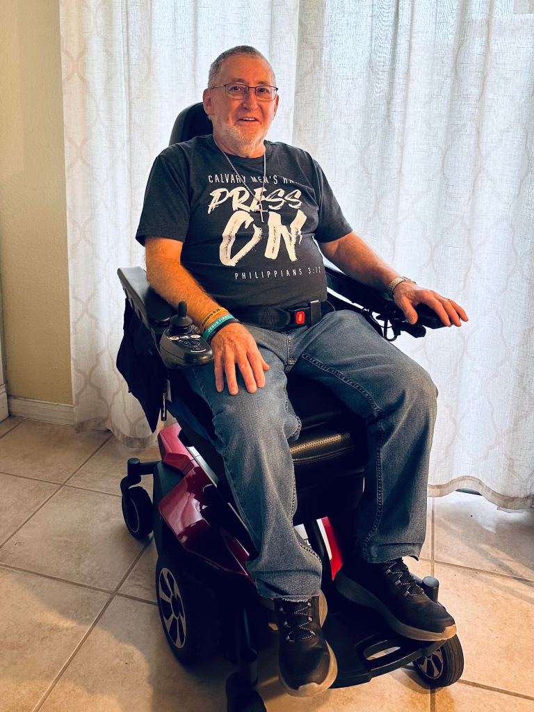 John in a motorized wheelchair